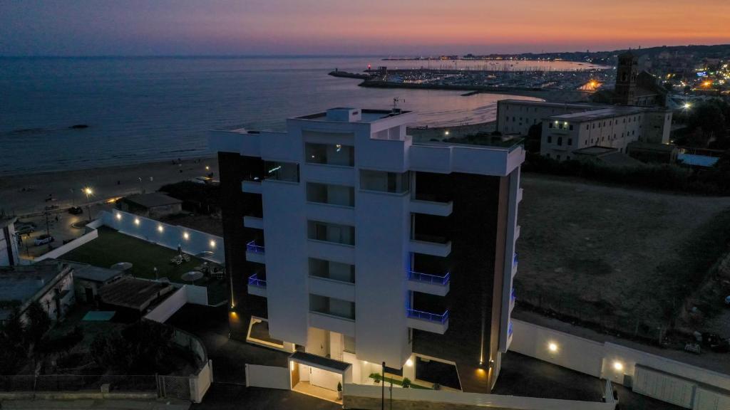 a building with a view of the ocean at night at I Bordin Home in Nettuno