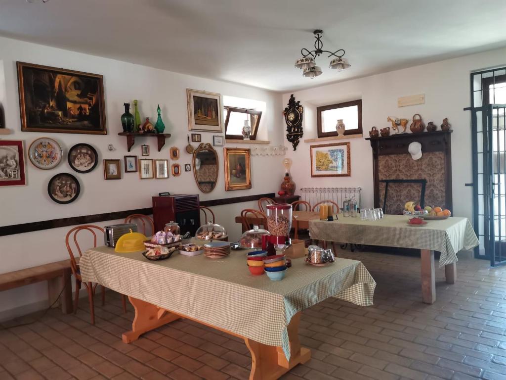 a living room with two tables and a fireplace at Foresteria del Re in Montelupone