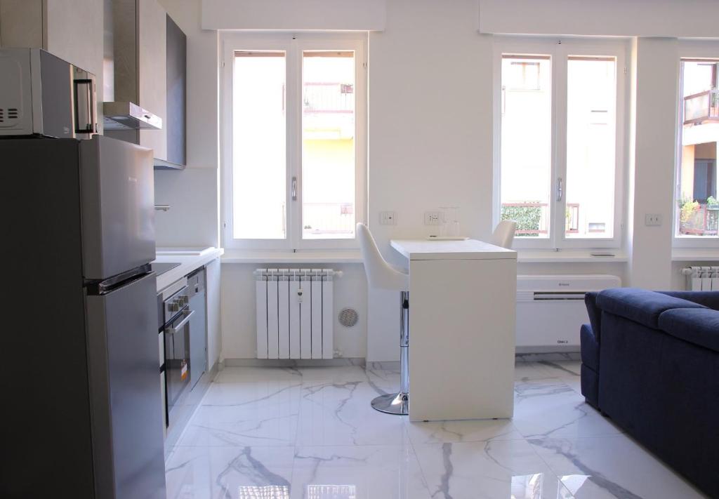 cocina blanca con mesa y sofá en Dreamich - Scavi Romani, en Desenzano del Garda