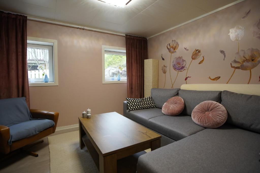 een woonkamer met een bank en een tafel bij Small cozy apartment by the sea in Havøysund