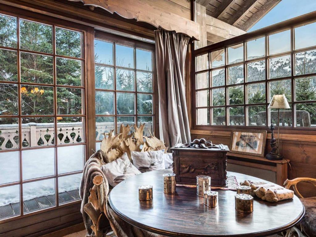 a living room with a table and some windows at Chalet Méribel, 8 pièces, 14 personnes - FR-1-565-40 in Les Allues