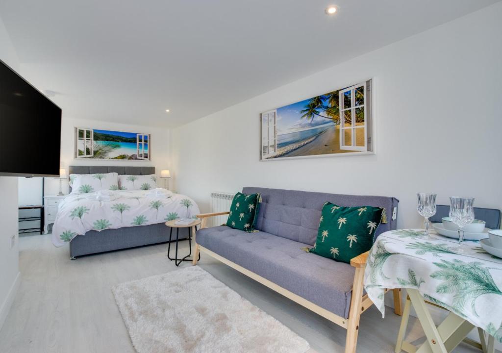 een woonkamer met een bank en een bed bij Idrella Studio in Saltdean