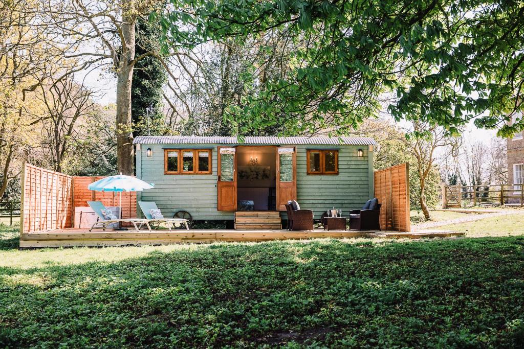 a tiny house sitting on a deck in a yard at Snowdrop Lodge, Walcot Hall Estate in Alkborough