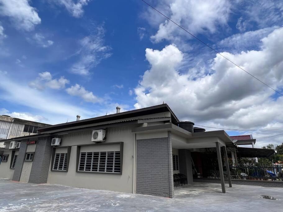a building with a blue sky and clouds at You&Me Corner Lot Homestay 17PAX in Port Dickson