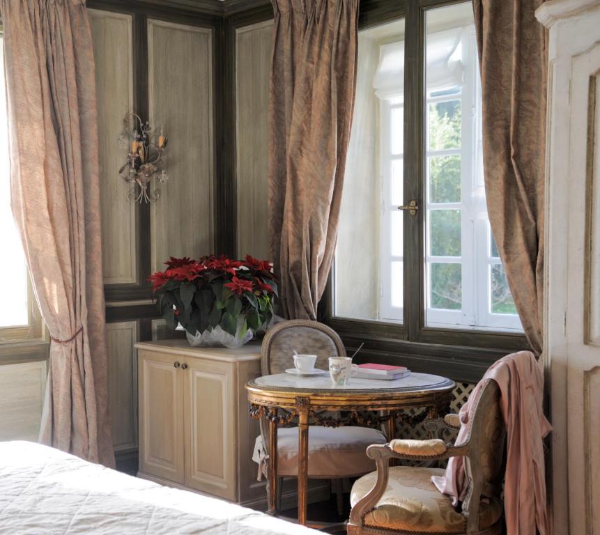 a bedroom with a table and chairs and a window at Hotel Villa Catarie in Guéthary