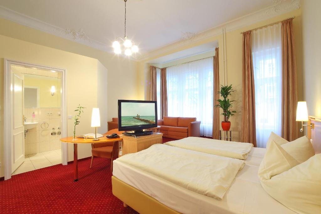 una camera d'albergo con due letti e una televisione di Hotel Vivaldi Berlin am Kurfürstendamm a Berlino