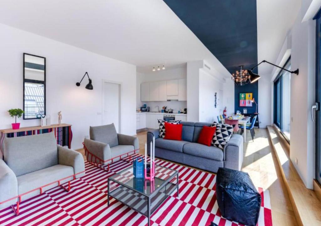 sala de estar con sofás y alfombra roja y blanca en Sweet Inn - Duomo View, en Milán