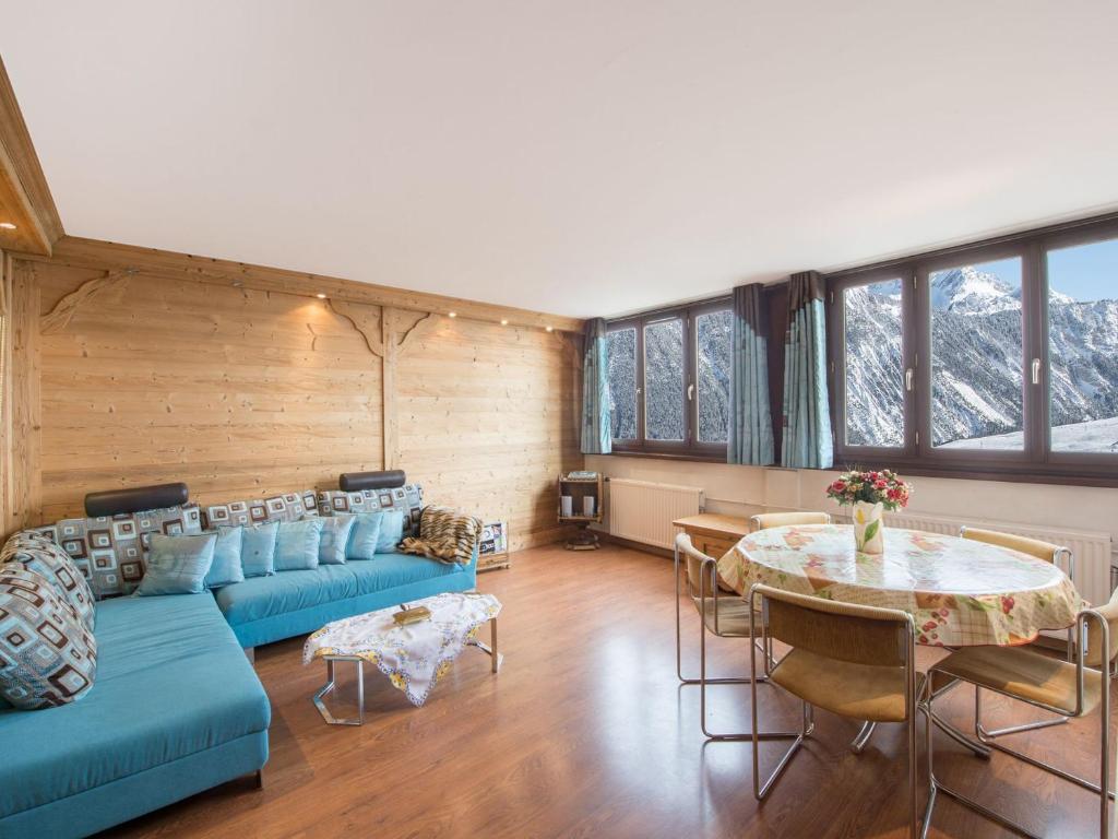 un salon avec un canapé bleu et une table dans l'établissement Appartement Courchevel 1850 avec 2 chambres et services inclus - FR-1-564-37, à Courchevel
