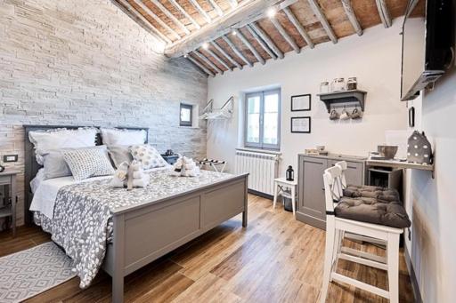 um quarto com uma cama e uma parede de tijolos em La Casina di Aldo em Montepulciano