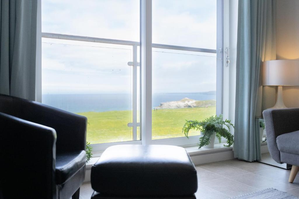 a living room with a large window with a view of the ocean at Stunning Sea Views, luxury apartment beaches & restaurants are a short walk away in Newquay