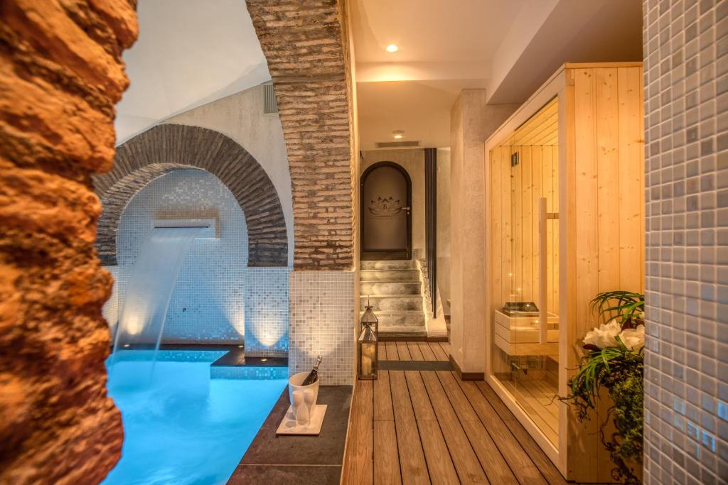 een zwembad in een huis met een bakstenen muur bij Boutique Relais Barozzi & SPA in Rome