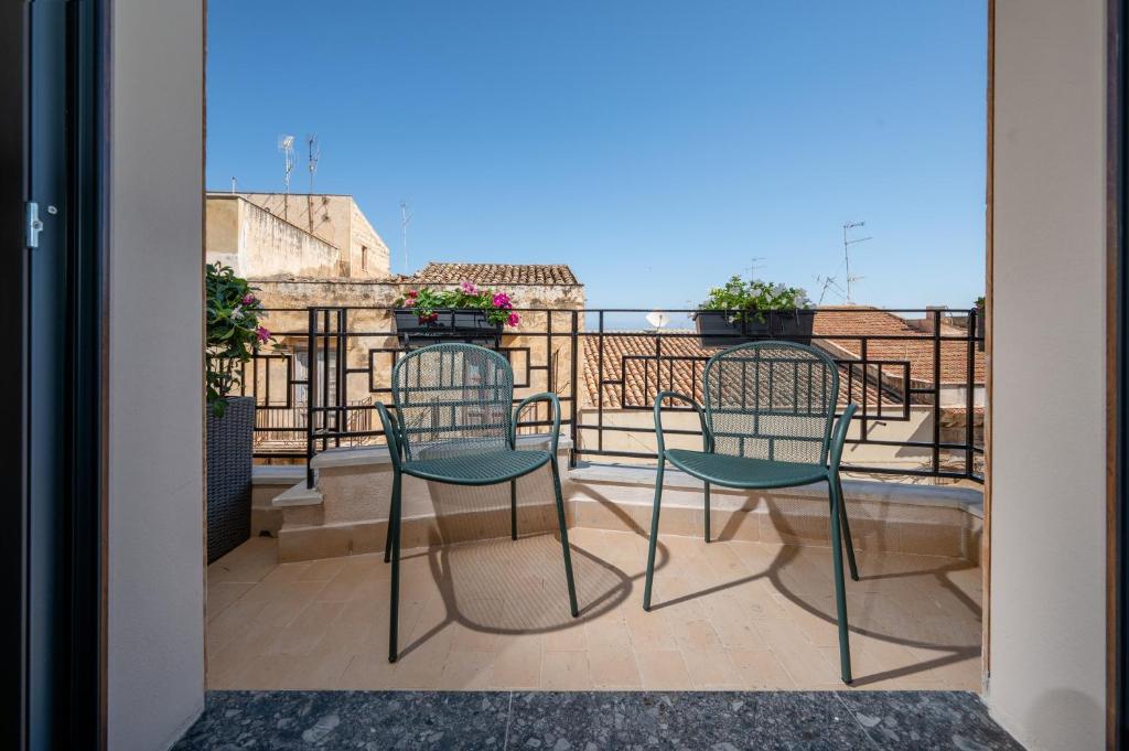 a balcony with two chairs and a table at BED 10.5 - DESIGN SUITE in Castellammare del Golfo