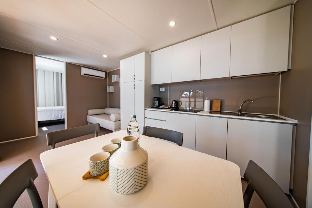 a kitchen and dining room with a table and chairs at Arena Stoja Camping Homes in Pula