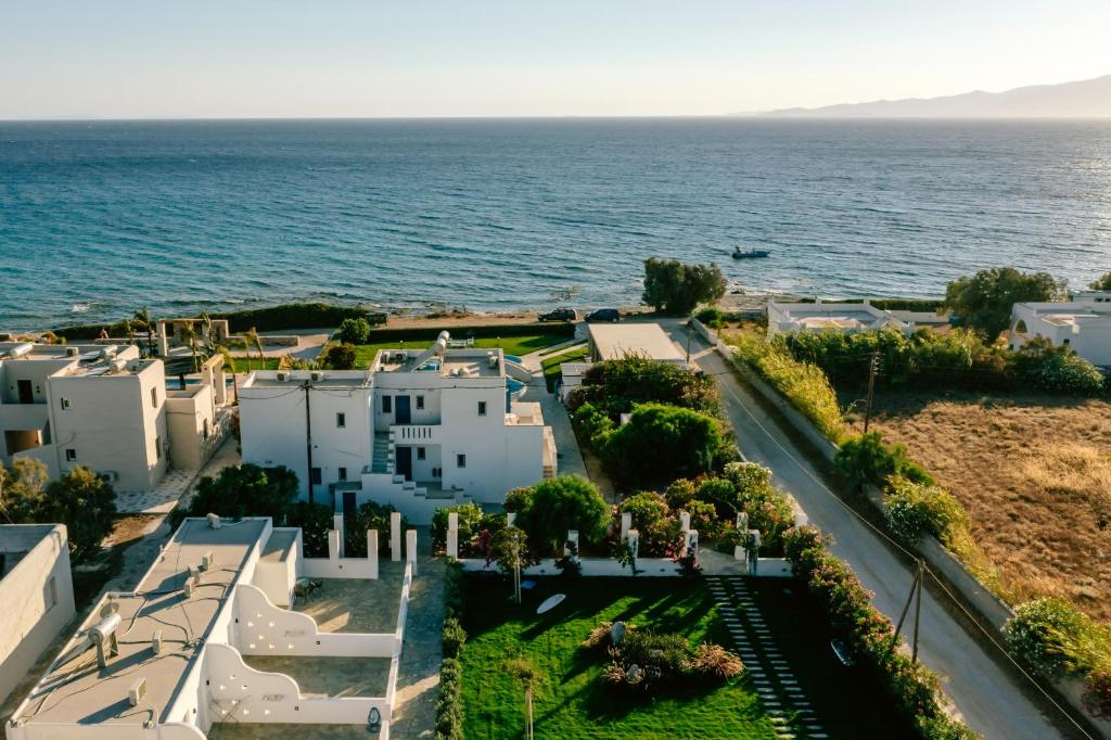 an aerial view of a white building next to the ocean at Blue Myth Studios in Kastraki