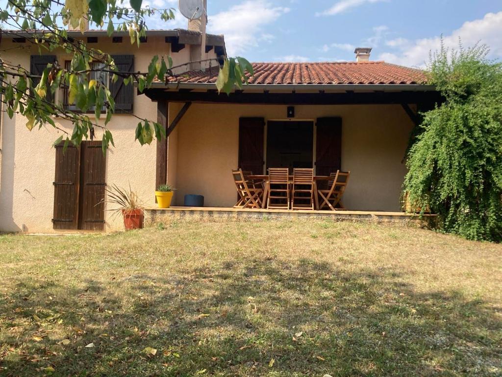 a house with a porch with a table and chairs at L'Azilienne, jolie maison à 2 pas du village - L'Azilienne, pretty house 2 steps from village in Le Mas-dʼAzil