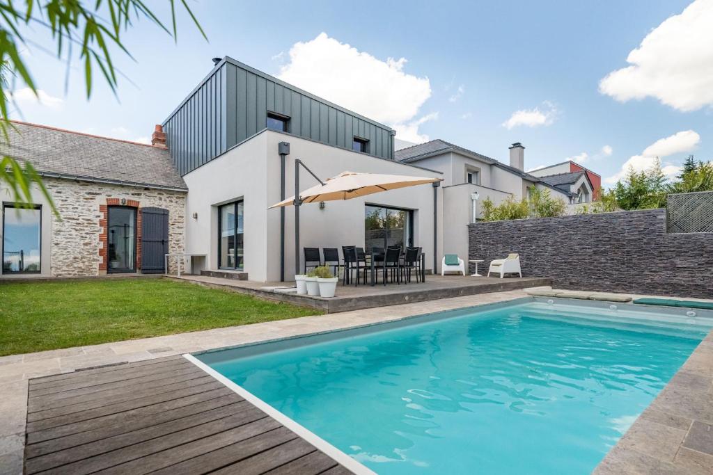 a swimming pool in the backyard of a house at Belle maison familiale et contemporaine avec piscine in Nantes