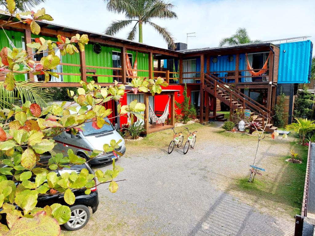 a house with a car parked in front of it at Pousada Container Eco Guarda in Guarda do Embaú