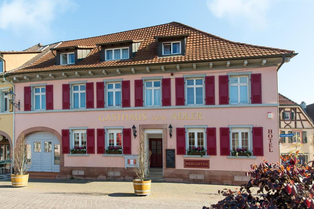 un edificio rosa con ventanas rojas y azules en Gasthaus Adler Ettenheim- mit self Check-In - Key Boxes, en Ettenheim