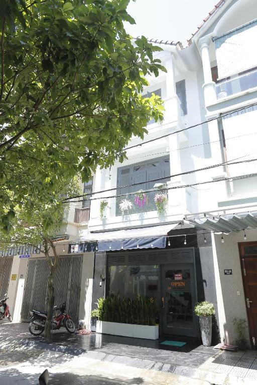 a building with a store front with a tree in front at CHIENHOA HOMESTAY in Danang