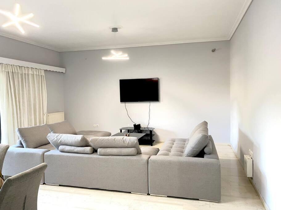 a living room with a couch and a flat screen tv at Renovated Condo in Athens in Athens