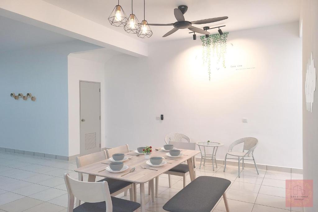 una sala da pranzo con tavolo, sedie e ventilatore a soffitto di Homely, Self Check-In, Wi-Fi, Guarded Community a Seremban