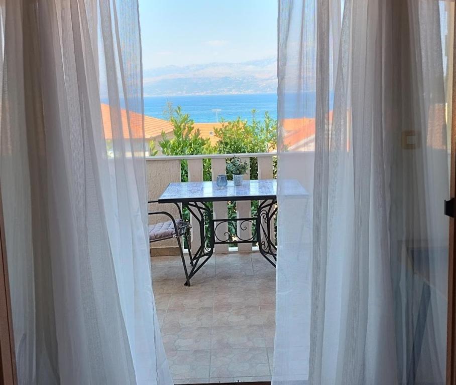 balkon ze stołem i widokiem na ocean w obiekcie Apartman Mediterraneo w mieście Supetar