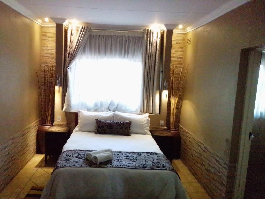 a bedroom with a bed in front of a window at Ditsaleng Bed and Breakfast in Vanderbijlpark