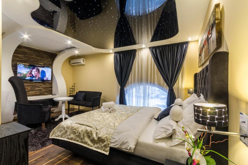 um quarto com uma cama grande e uma televisão em Madison - Square Sava em Belgrado