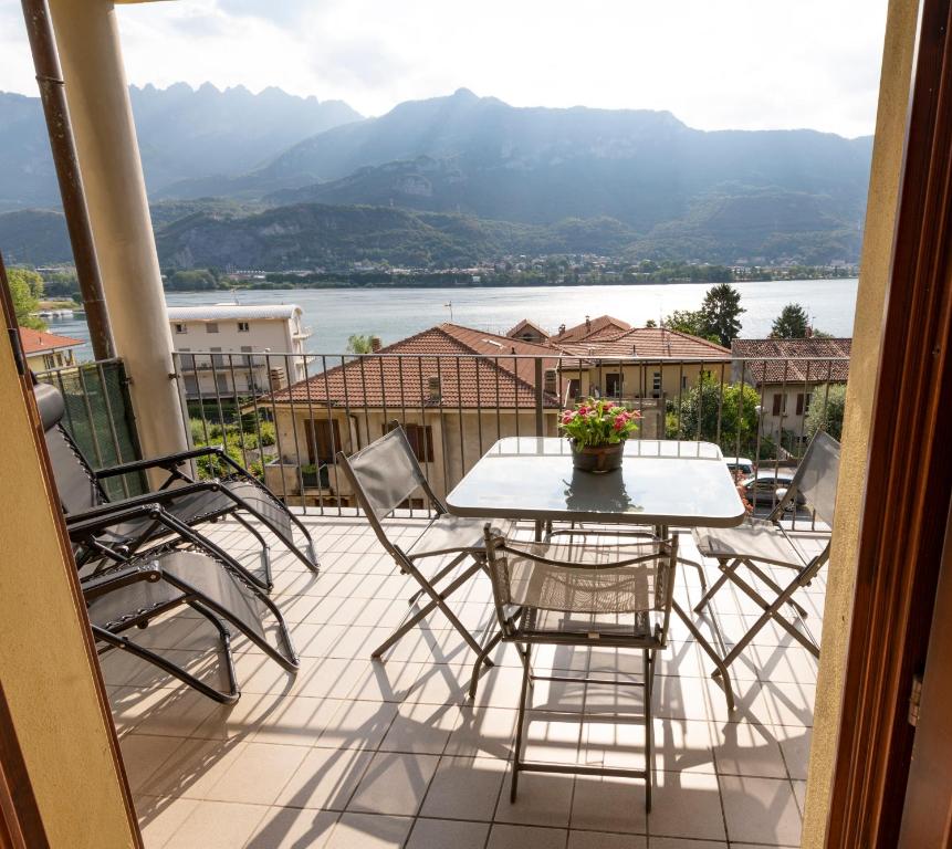 a patio with a table and chairs on a balcony at View House - Lake Como in Pescate