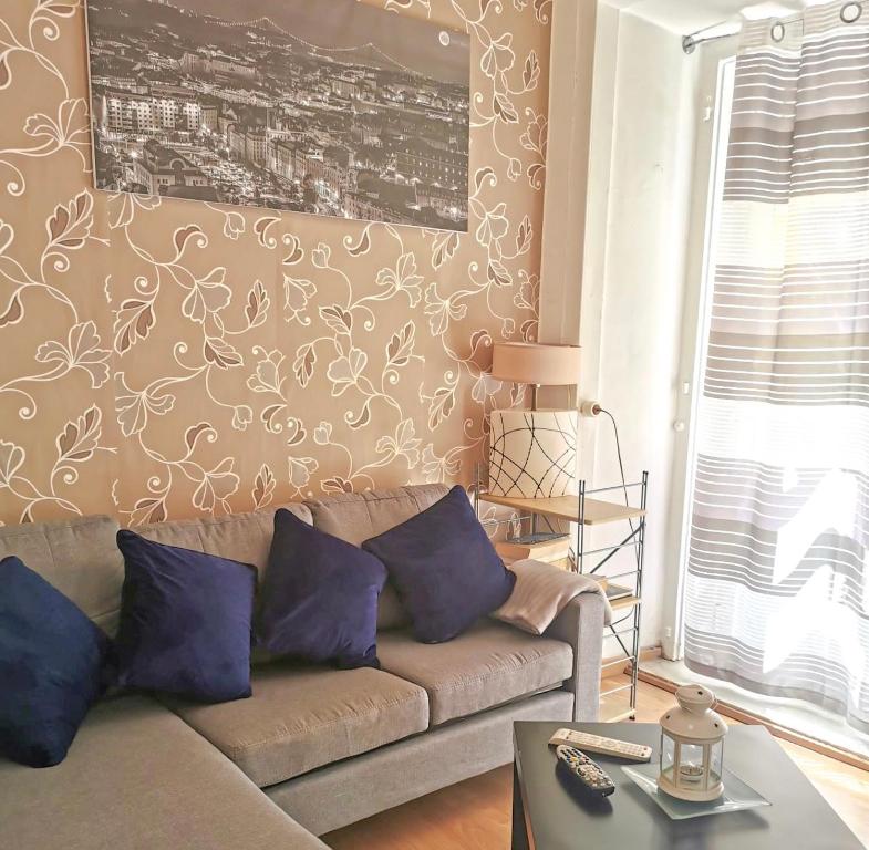 sala de estar con sofá y almohadas moradas en Luz Soriano Apartment, en Lisboa