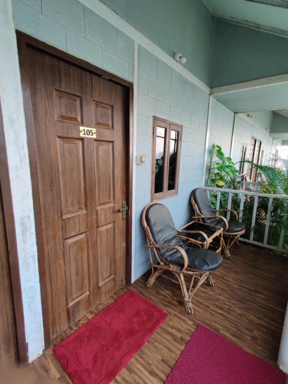 a room with two chairs and a wooden door at Regina's Place in Mandrem