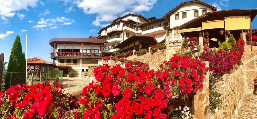 un montón de flores rojas delante de un edificio en Hotel Manastir Berovo, en Berovo