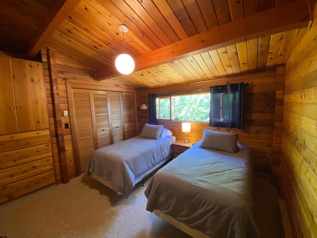 a bedroom with two beds in a wooden cabin at April Point Harbour House in Quathiaski Cove