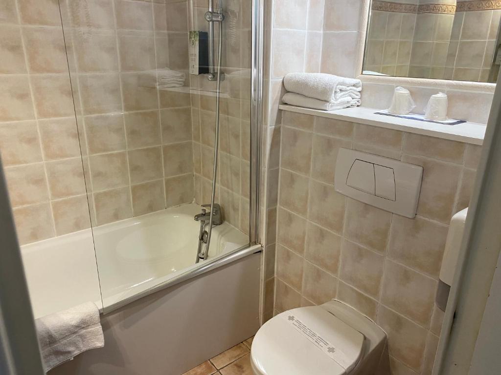 a bathroom with a shower and a toilet and a sink at Kyriad Montpellier Aéroport - Gare Sud de France in Mauguio
