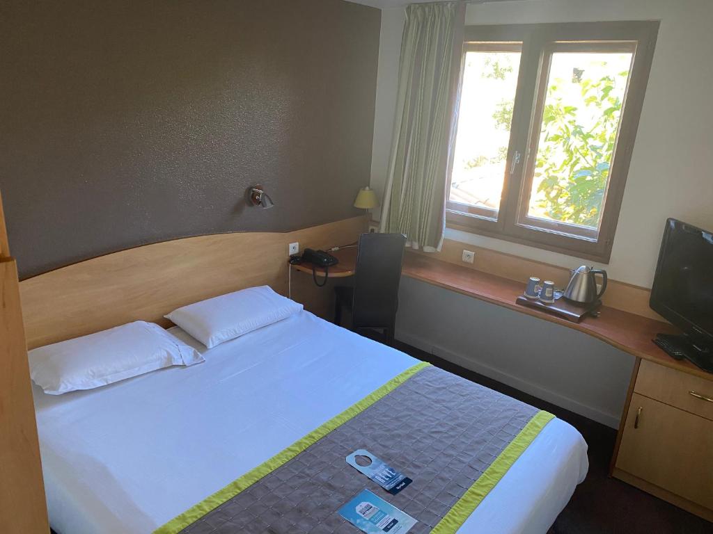 a hotel room with a bed and a window at Kyriad Montpellier Aéroport - Gare Sud de France in Mauguio