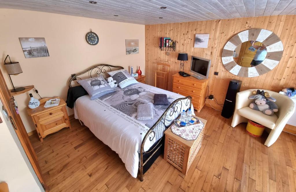 1 dormitorio con 1 cama, 1 silla y TV en Ty Cosy, Chambre privée en Pluméliau