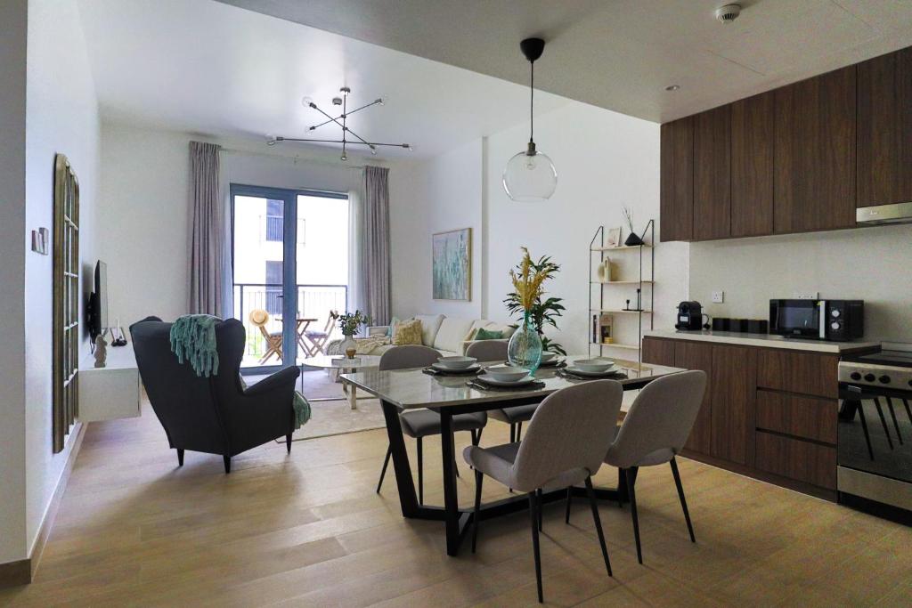 eine Küche und ein Wohnzimmer mit einem Tisch und Stühlen in der Unterkunft HiGuests - Stylish Apt With Stunning Beach Views and Pools in Dubai