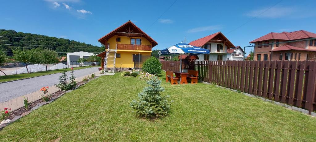 ein Haus mit einem Hof mit einem Zaun und einem Haus in der Unterkunft Casa Ferenczi Vendégház in Sovata