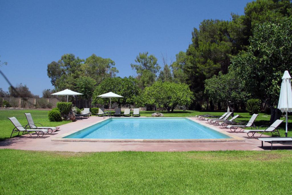 烏真托的住宿－Masseria Cristo，一个带草坪椅和遮阳伞的游泳池