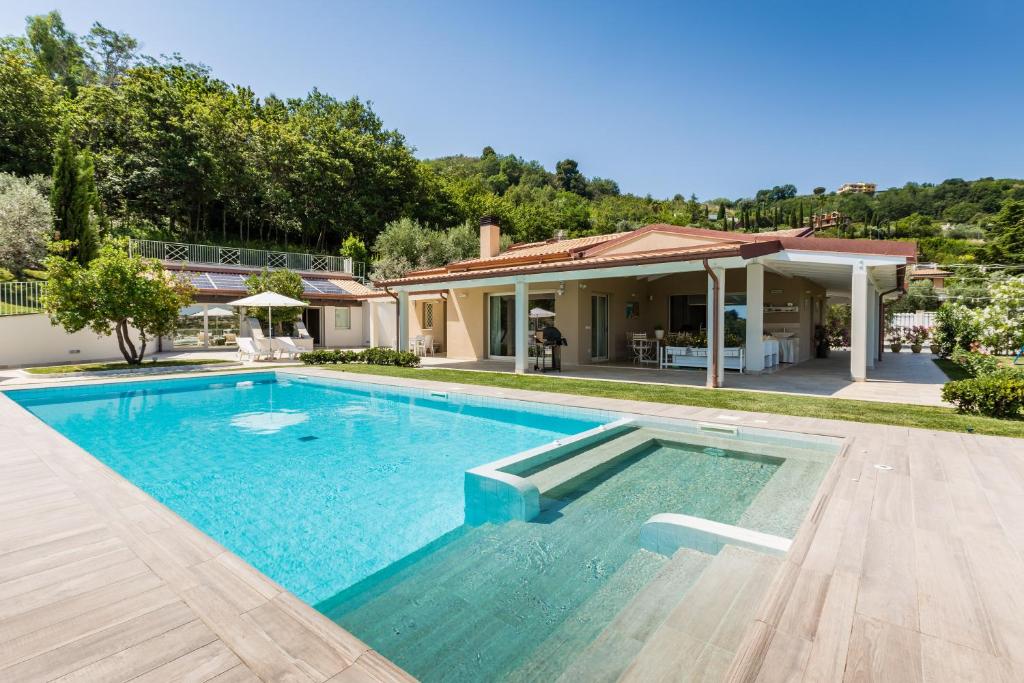 a swimming pool in front of a house at Villa Lerant in Acquaviva Picena
