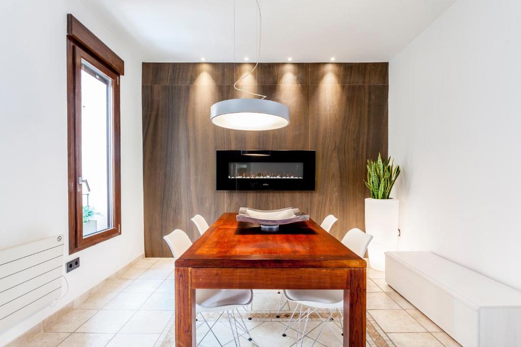 comedor con mesa de madera y sillas blancas en CASA ESPECTACULAR DE DISEÑO CON JARDIN INTERIOR en Valencia