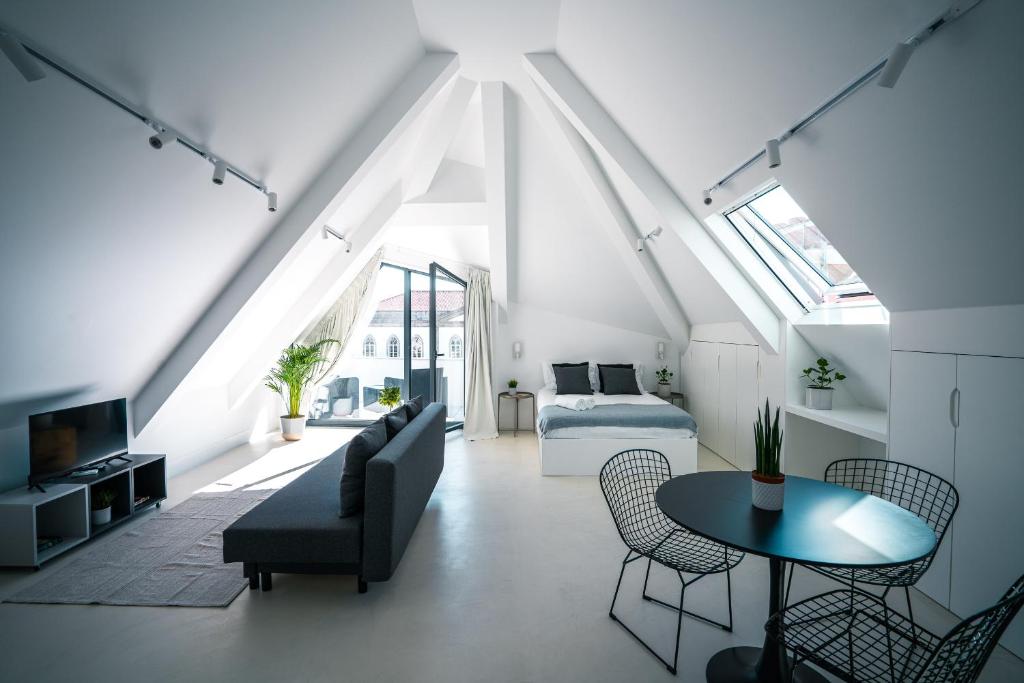 a living room with a bed and a couch and a table at PORTARIA HOUSING in Aveiro