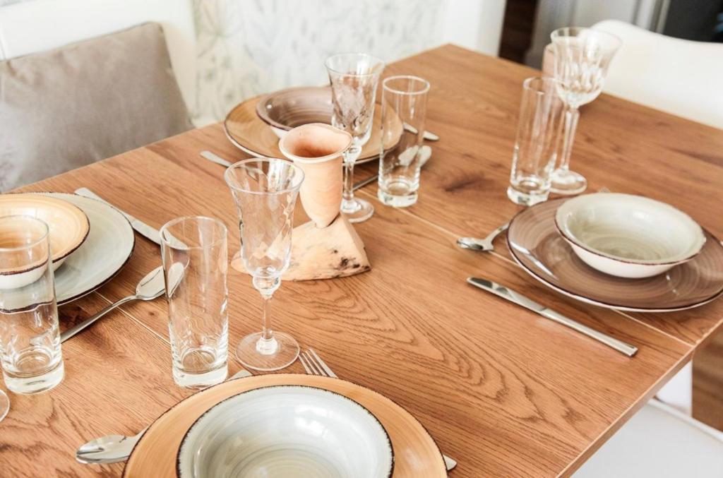 a wooden table with plates and glasses on it at Ferienwohnung Familienglück in Tutzing