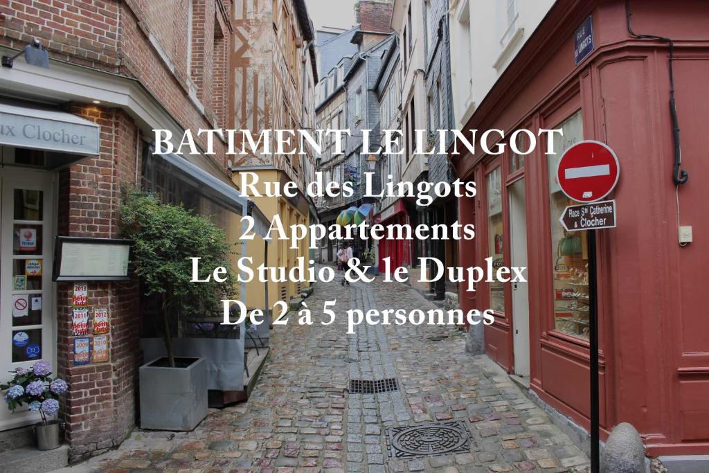 une rue avec un panneau sur le côté d'un bâtiment dans l'établissement Les Maisons de Maje - Le Lingot, à Honfleur