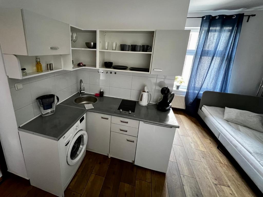 a kitchen with a sink and a washing machine at eM Apartment 17 in Katowice