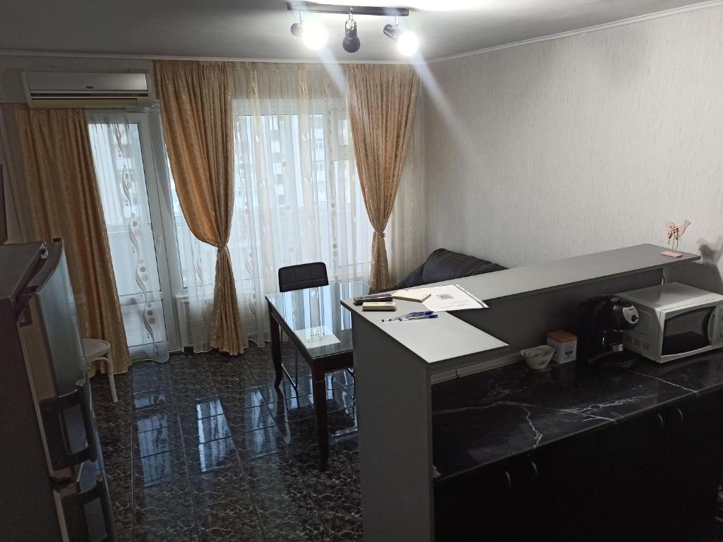 Habitación con escritorio, microondas y mesa. en Апартамент Арена Бургас 5+1 човека, en Burgas