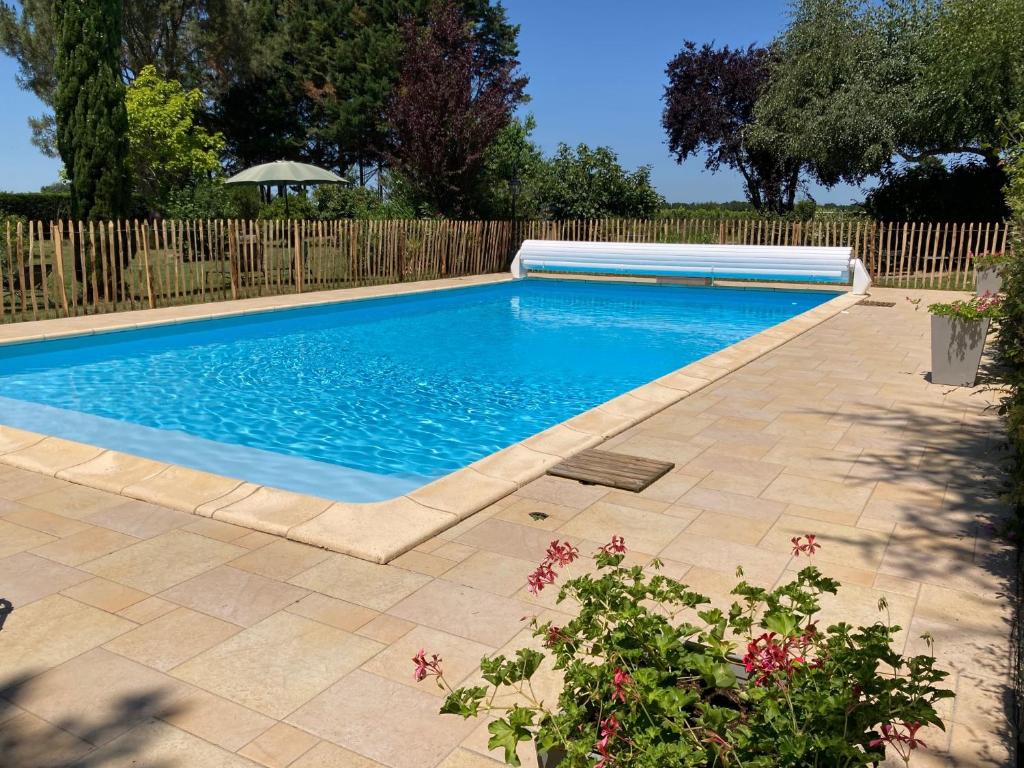 a swimming pool in a yard with a wooden fence at Gites le Mathelin in Lamothe-Montravel