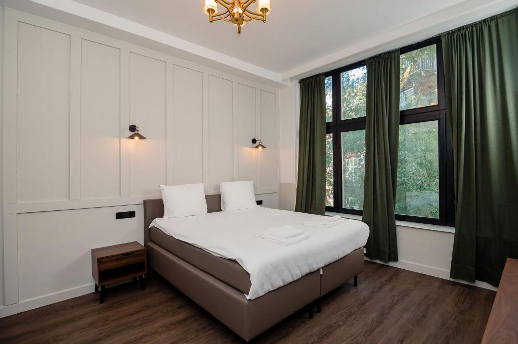 - une chambre avec un lit et une grande fenêtre dans l'établissement Mr.Lewis Rotterdam, à Rotterdam