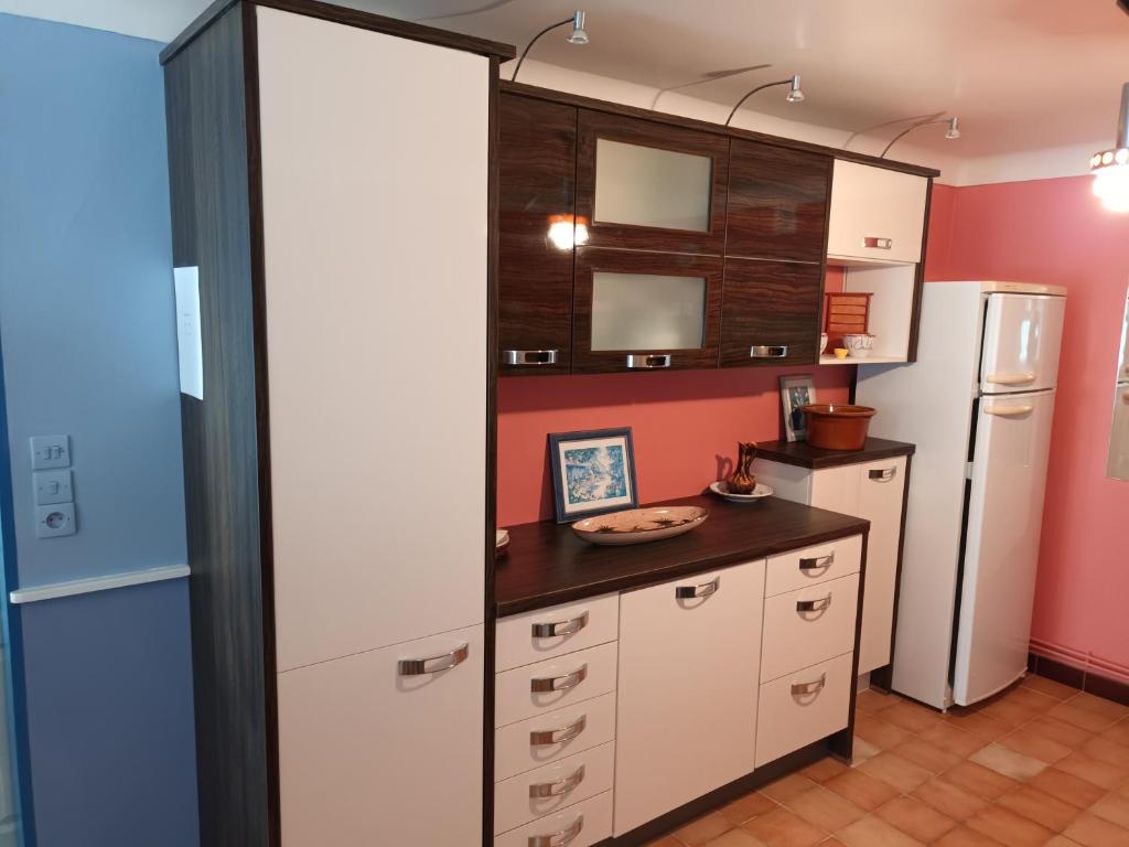 a kitchen with white cabinets and a refrigerator at Martine in Rouffignac Saint-Cernin