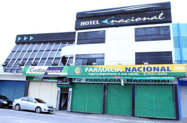 a building with green doors and a car parked in front at Hotel Nacional in Arapiraca